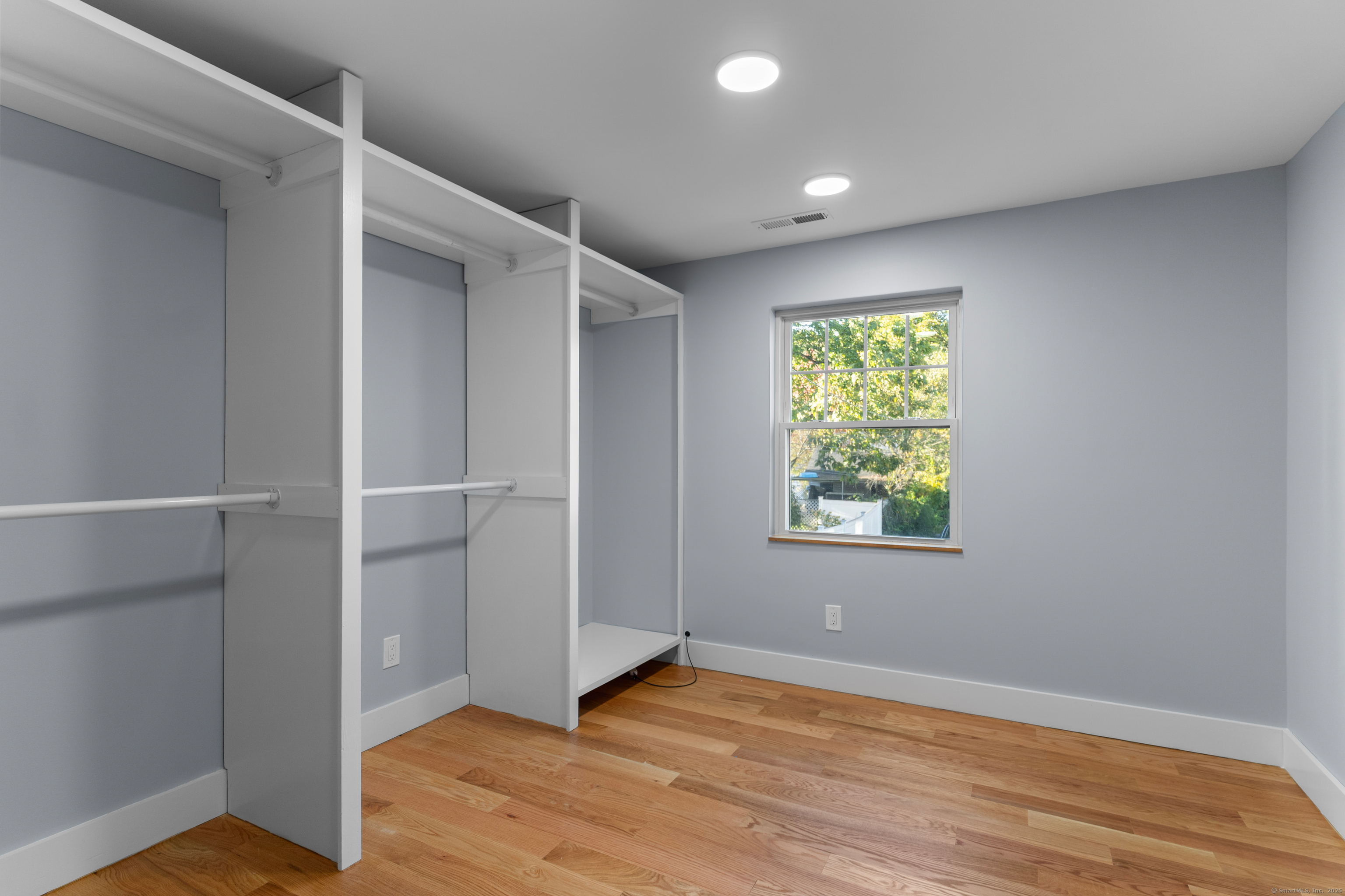 123 Exeter Street Bridgeport, CT 06606 - Photo 11 of 26 an empty room with wooden floor closet and windows