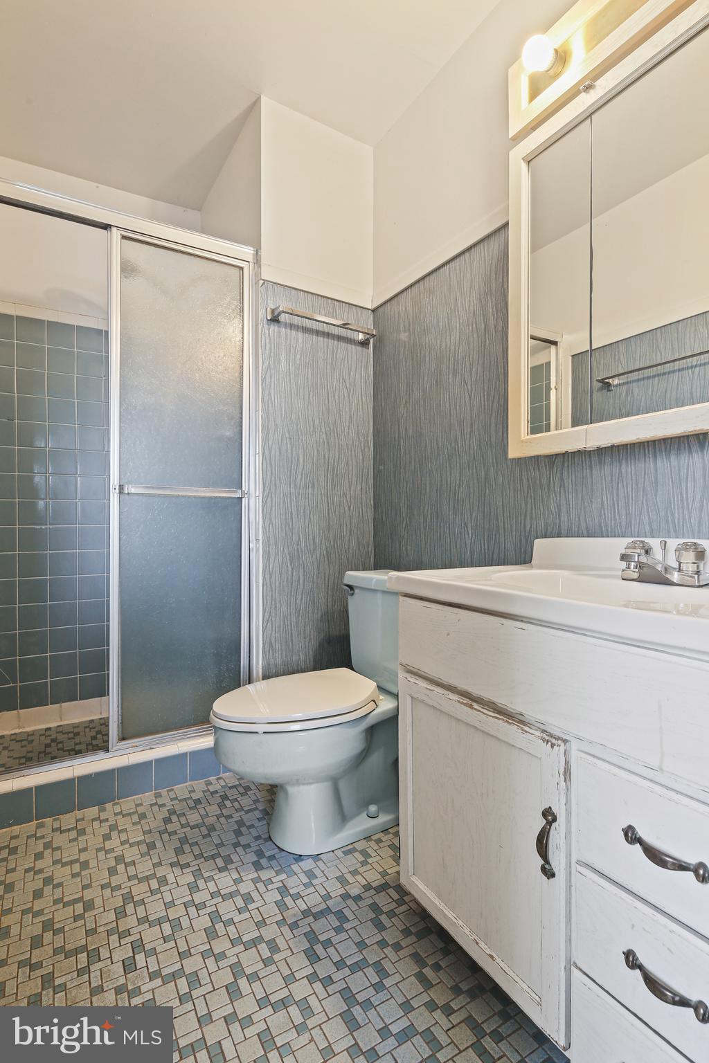 6215 Roblynn Road Laurel, MD 20707 - Photo 15 of 38 a bathroom with a sink a toilet a glass door shower and a mirror