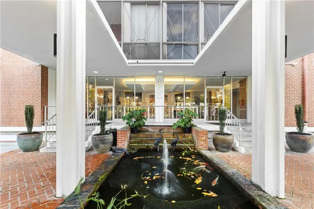 a living room with furniture floor to ceiling window and potted plants