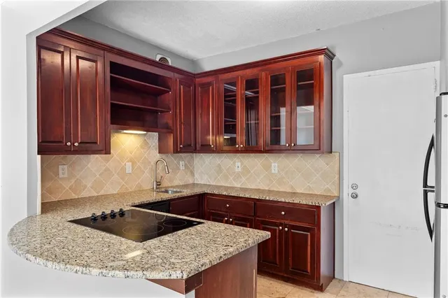 a kitchen with granite countertop a sink and a stove