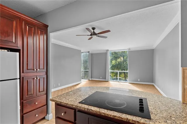 a view of kitchen with granite countertop sink and refrigerator
