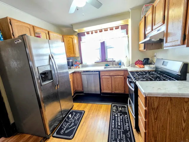 a kitchen with stainless steel appliances a stove a sink and a refrigerator