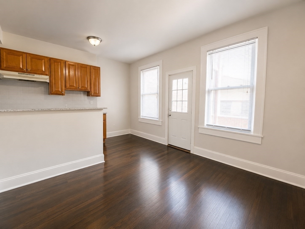 746 Broadway, Unit 2 Chelsea, MA 02150 - Photo 3 of 13 a view of an empty room with wooden floor and a window