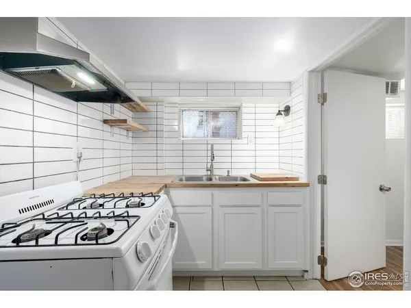 a kitchen with sink a stove and cabinets