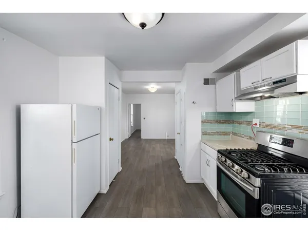 a kitchen with stainless steel appliances granite countertop a refrigerator and a stove
