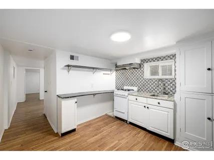 a kitchen with granite countertop white cabinets and white appliances