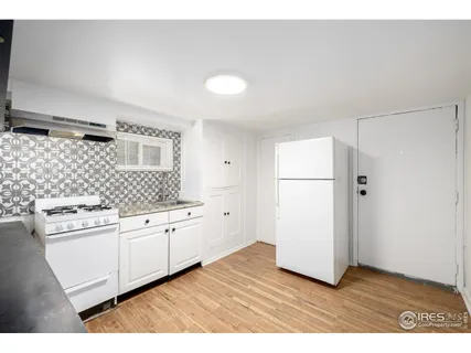 a kitchen with granite countertop white cabinets and white appliances