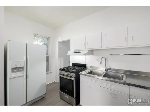 a kitchen with kitchen island granite countertop a sink cabinets and stainless steel appliances