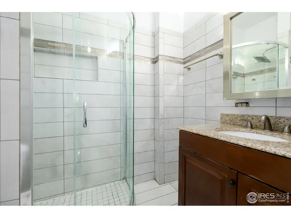 a bathroom with a sink shower and a mirror