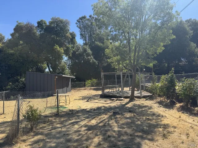 a view of a backyard with wooden fence