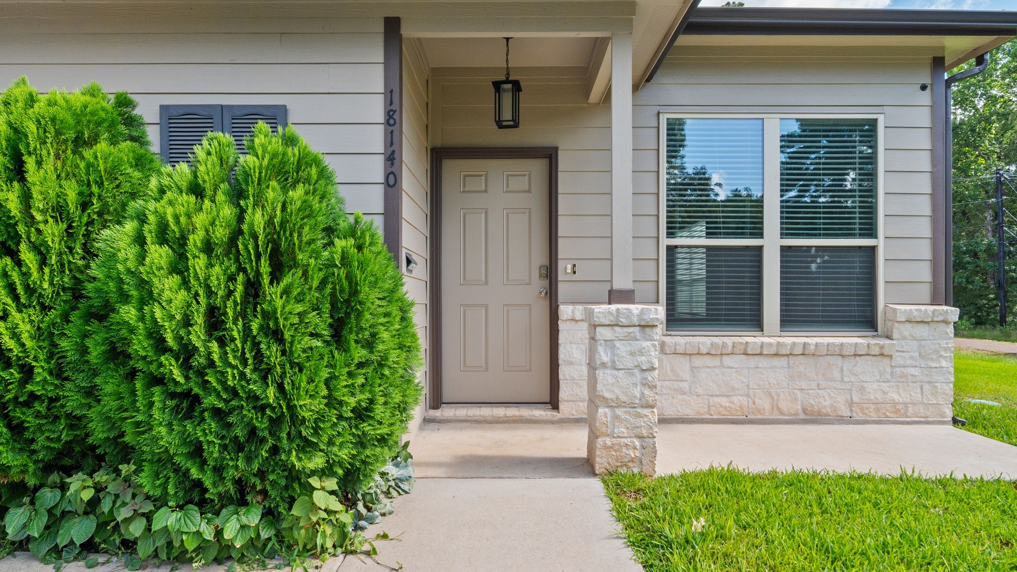 18140 Mail Rte Road Montgomery, TX 77316 - Photo 3 of 26 Welcoming covered front entry with attractive landscaping and a bright picture window.