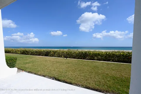 a view of a big yard with an ocean view