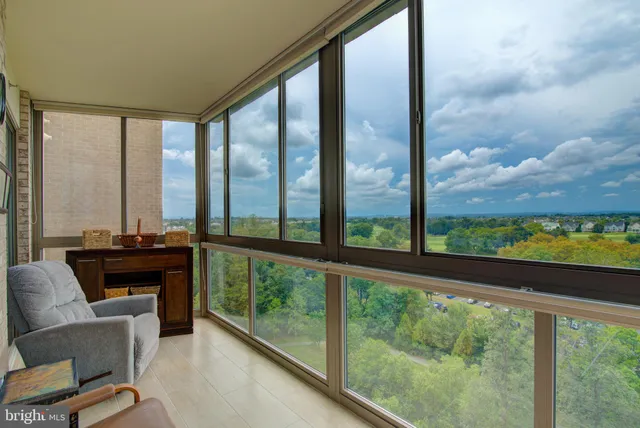 a living room with furniture and a floor to ceiling window