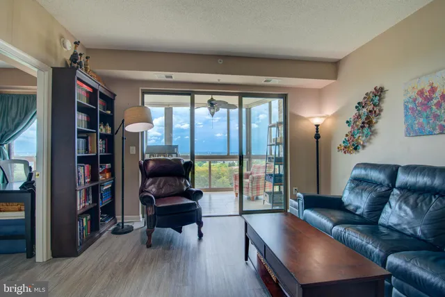 a living room with furniture a flat screen tv and kitchen view
