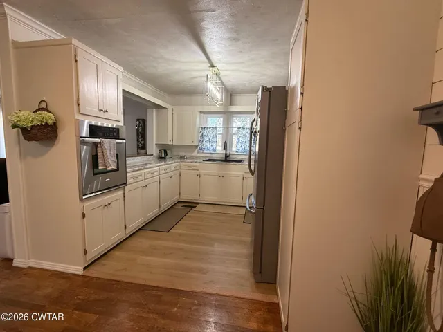 a view of a livingroom with wooden floor and staircase