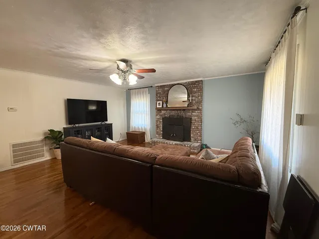 a living room with furniture a flat screen tv and a window