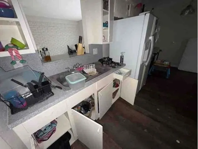 a kitchen with sink refrigerator and wooden floor