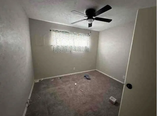 en empty room with windows and fan