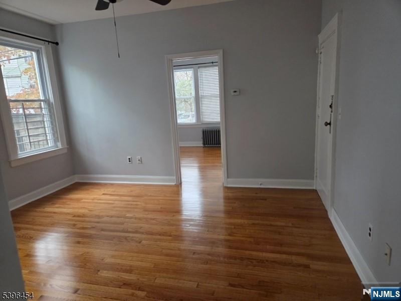 292 Leslie Street, Unit 292 Newark, NJ 07112 - Photo 2 of 9 an empty room with wooden floor and windows