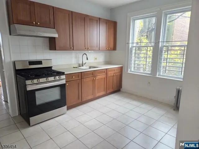 a kitchen with granite countertop a stove sink and cabinets