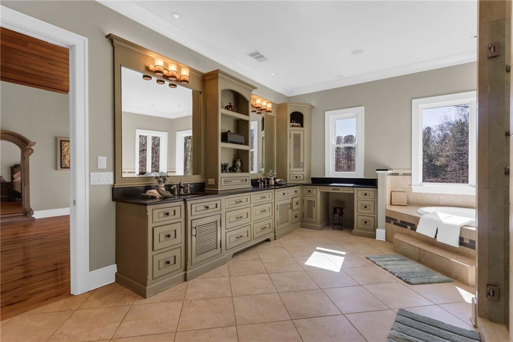 1086 Arbor Hill Road Canton, GA 30115 - Photo 27 of 98 a large bathroom with a large mirror vanity sink and a bath tub