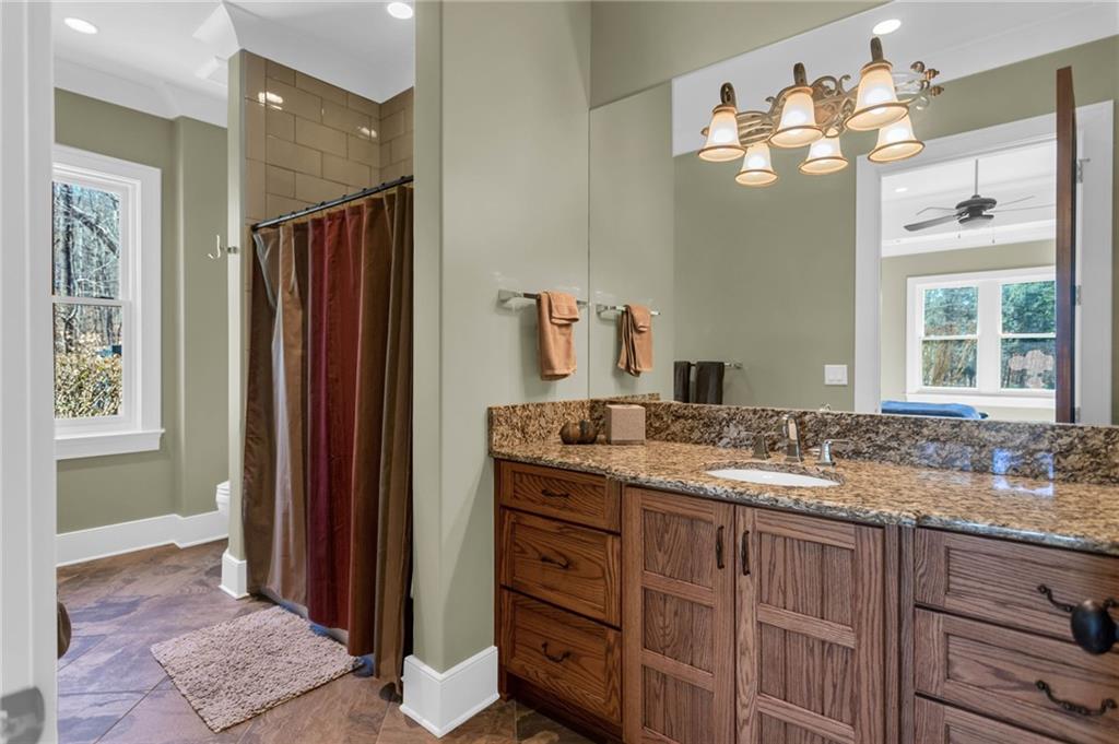 1086 Arbor Hill Road Canton, GA 30115 - Photo 54 of 98 a bathroom with a granite countertop sink a large mirror and a shower