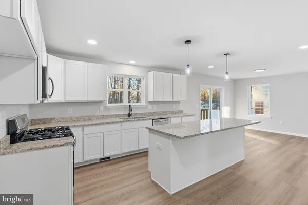 a kitchen with stainless steel appliances granite countertop a sink stove and cabinets
