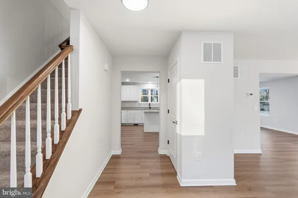 a view of a hallway with wooden floor and staircase