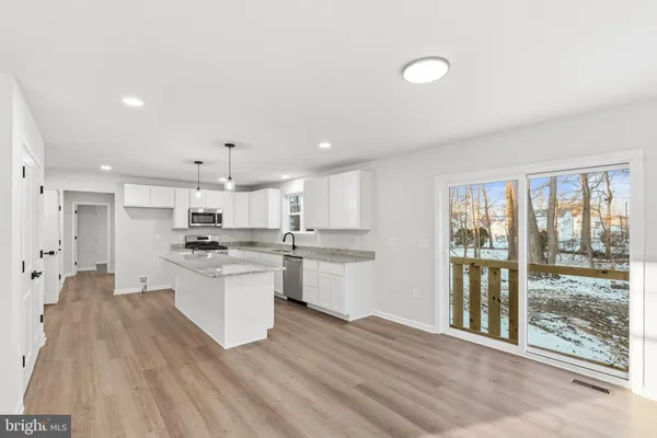 a large kitchen with kitchen island a sink stainless steel appliances and cabinets