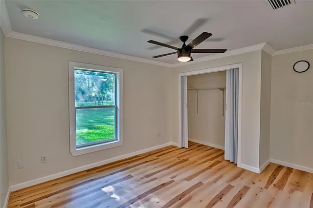 a view of a livingroom with wooden floor and a ceiling fan