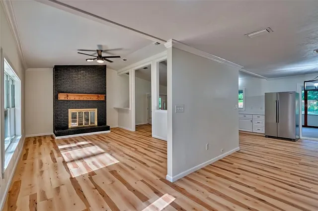 a view of empty room with wooden floor and fireplace