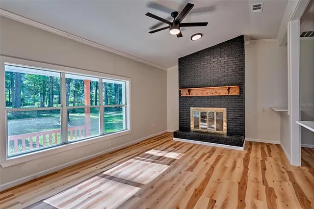 a view of an empty room with a fireplace and a window