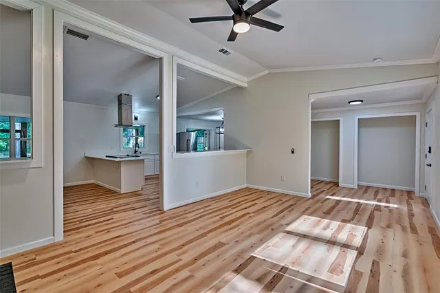 a view of a room with wooden floor and a ceiling fan