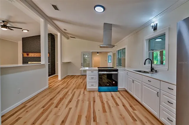 a kitchen with stainless steel appliances a stove top oven a sink and a refrigerator