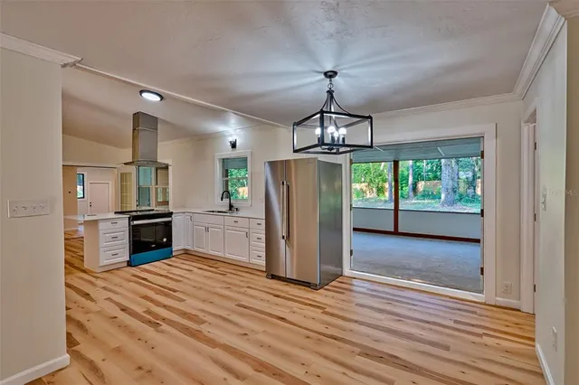 a view of a kitchen with refrigerator and wooden floor