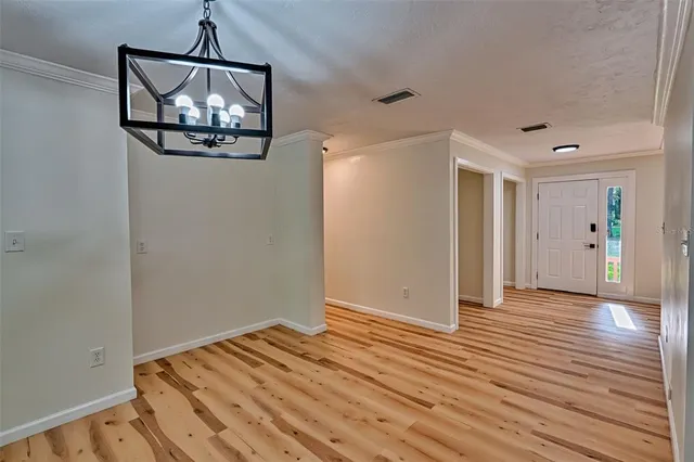 a view of a room with wooden floor chandelier and closet