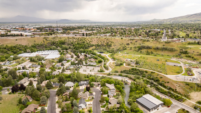1552 Sumac Drive Logan, UT 84321 - Photo 63 of 72 Expansive aerial perspective showcasing a residential neighborhood with mature trees, winding roads, and a visible waterway