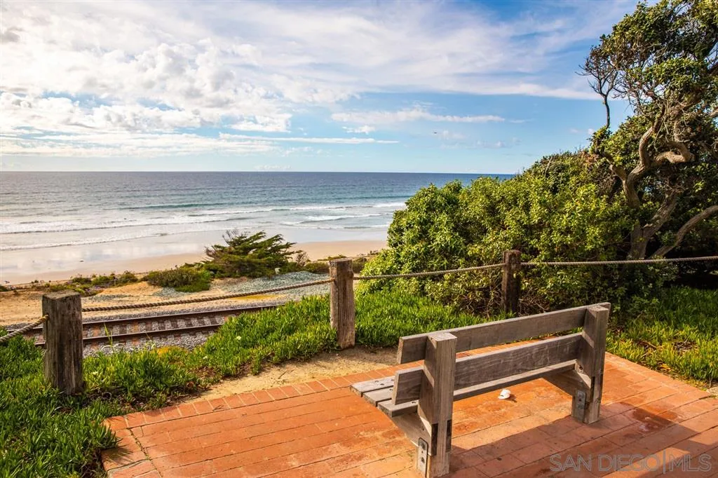692 Rimini Road Del Mar, CA 92014 - Photo 16 of 25 a view of a bench in the garden near a lake