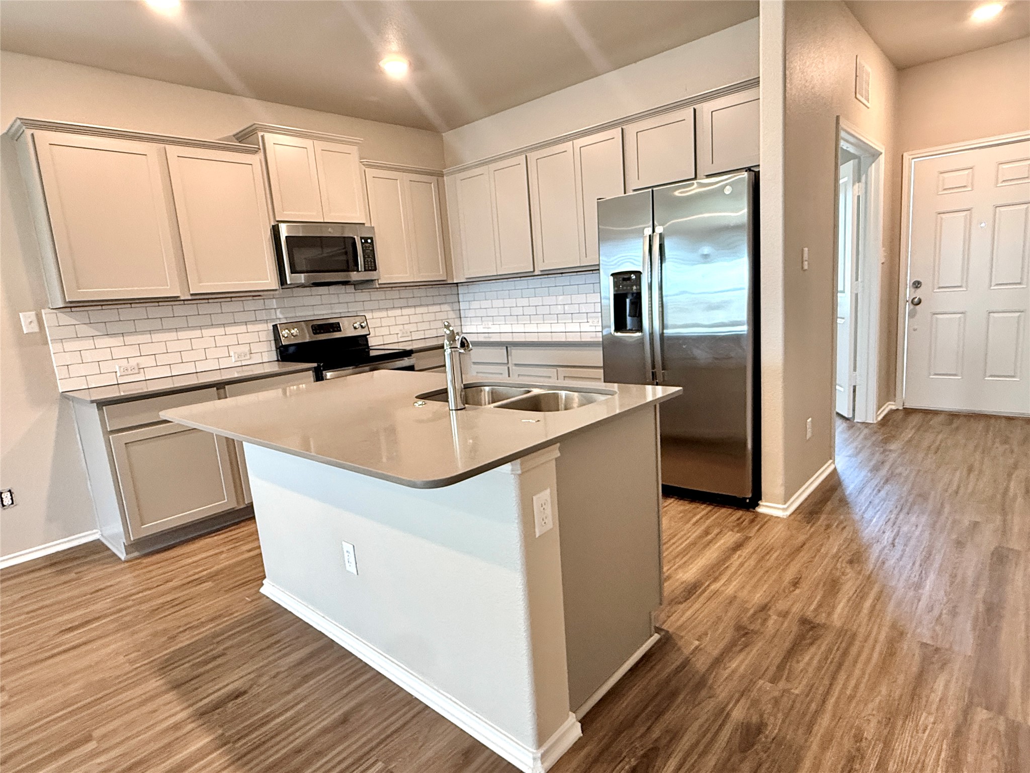 129 Perfect World Loop Jarrell, TX 76537 - Photo 7 of 31 A well-appointed kitchen showcasing contemporary appliances and rich wood flooring.