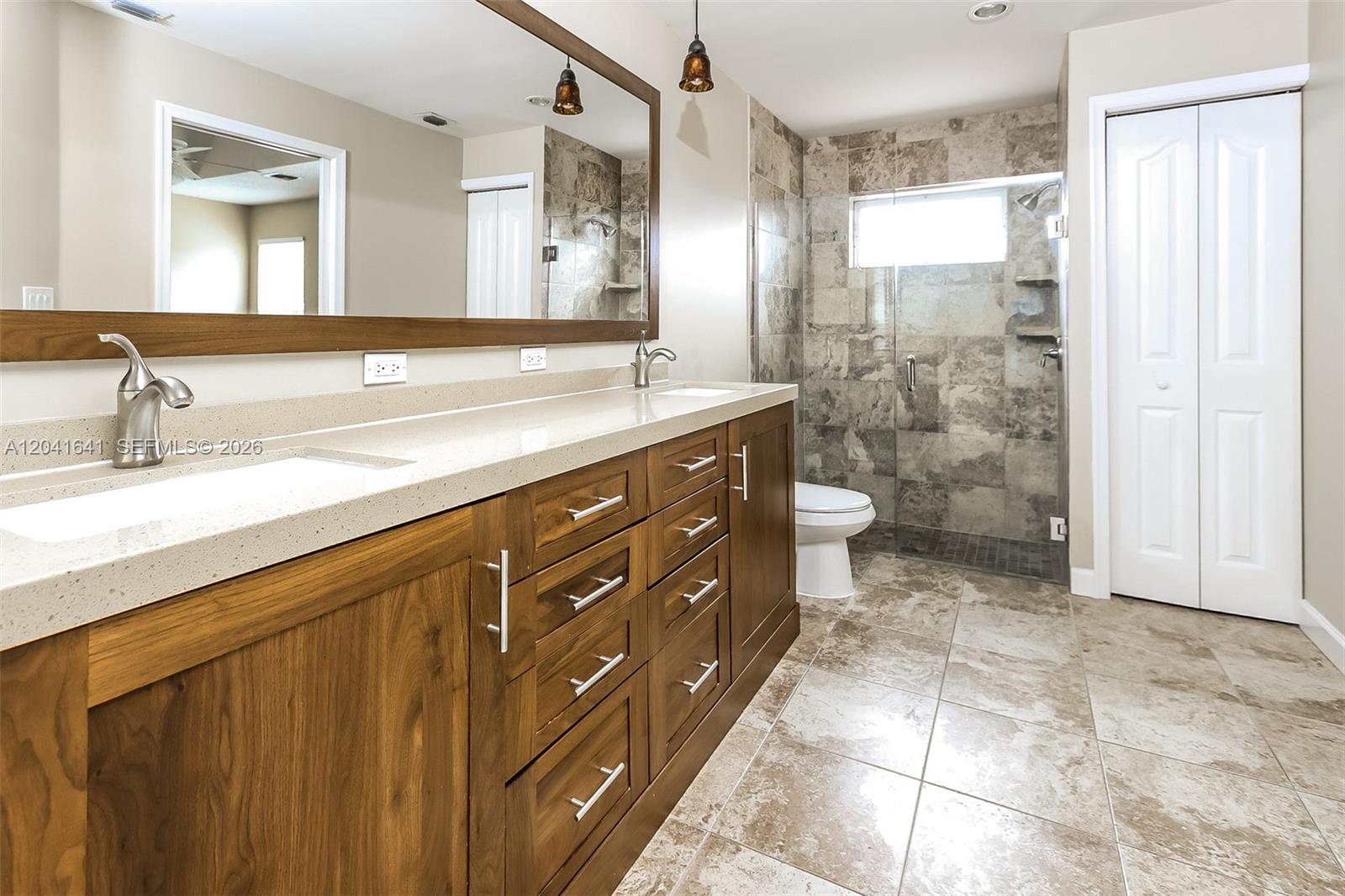 6484 Robinson Street Jupiter, FL 33458 - Photo 12 of 15 a bathroom with a double vanity sink toilet and shower