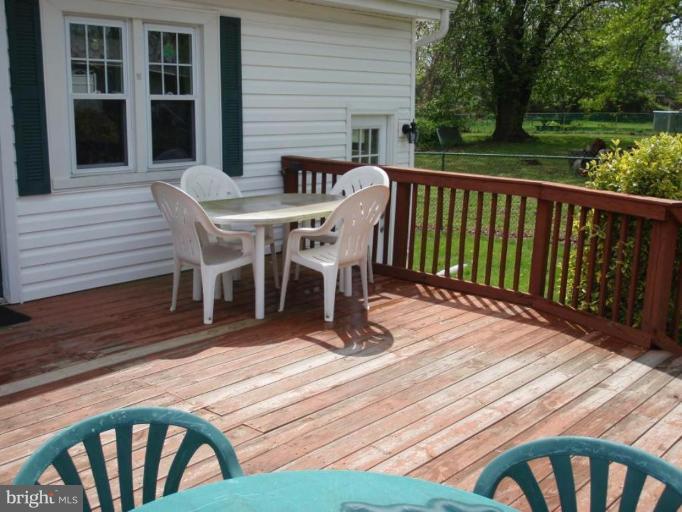 7917 Shore Road Sparrows Point, MD 21219 - Photo 2 of 16 a view of a patio with table and chairs with wooden floor and fence