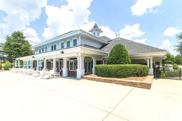 a view of a white house with a large tree in front of it