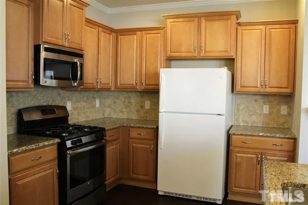a kitchen with a refrigerator stove and microwave