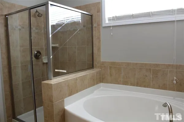 a bathroom with a white bath tub and a shower