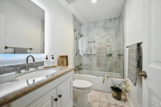 a bathroom with a granite countertop sink toilet and shower