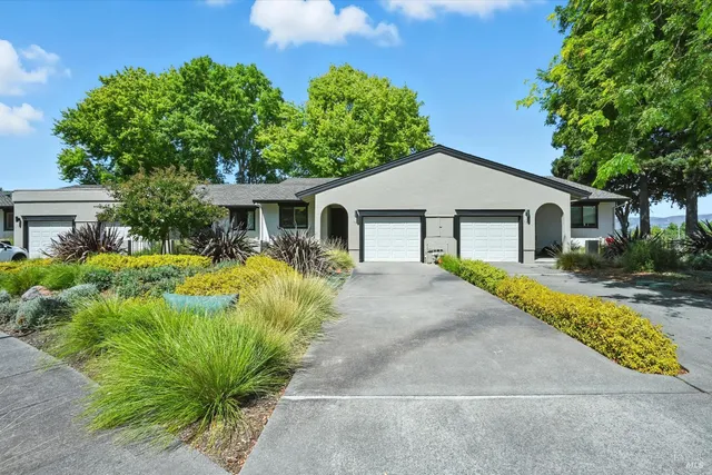 a front view of a house with a garden