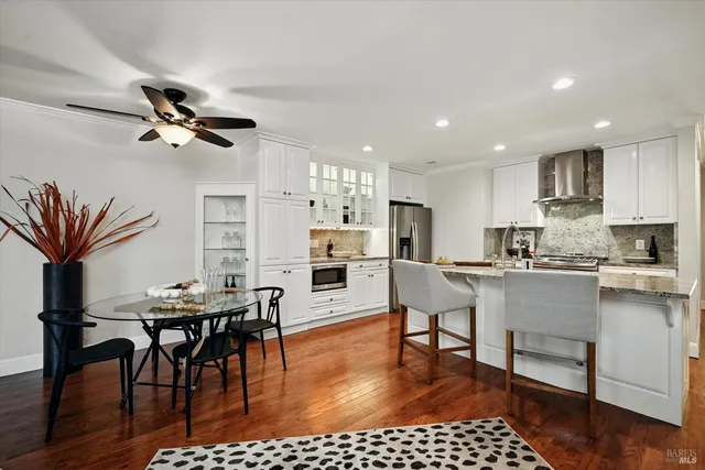 a living room with stainless steel appliances kitchen island granite countertop furniture and a dining table