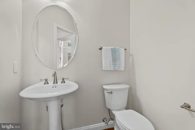 a bathroom with a toilet a sink and mirror
