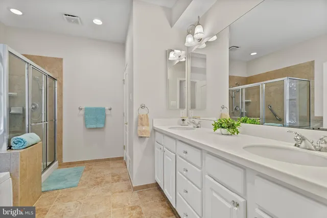 a spacious bathroom with a granite countertop sink a mirror and a shower