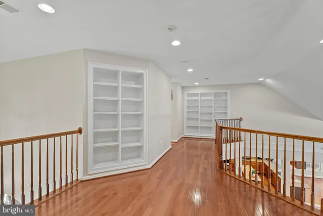 a view of a hallway with wooden floor and windows